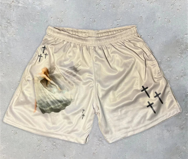 Beige shorts with graphic designs on a gray surface